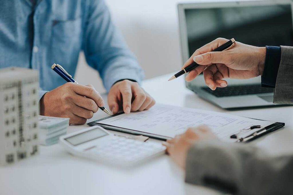 A family sitting at a kitchen table reviewing insurance documents together.