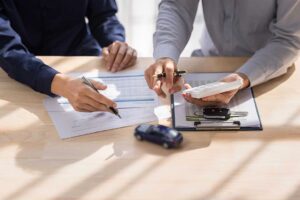 A family reviews car insurance documents together at their kitchen table.