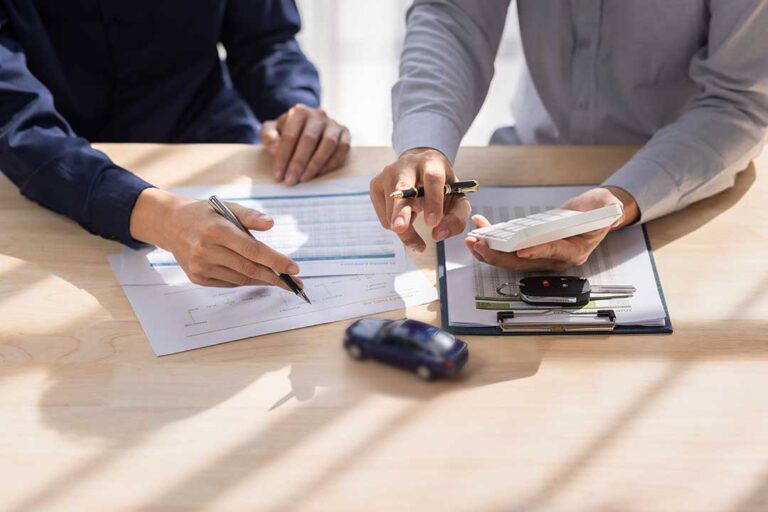 A family reviews car insurance documents together at their kitchen table.